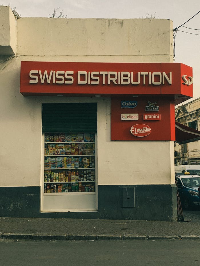 Street view of a store with a prominent Swiss Distribution sign and product display.